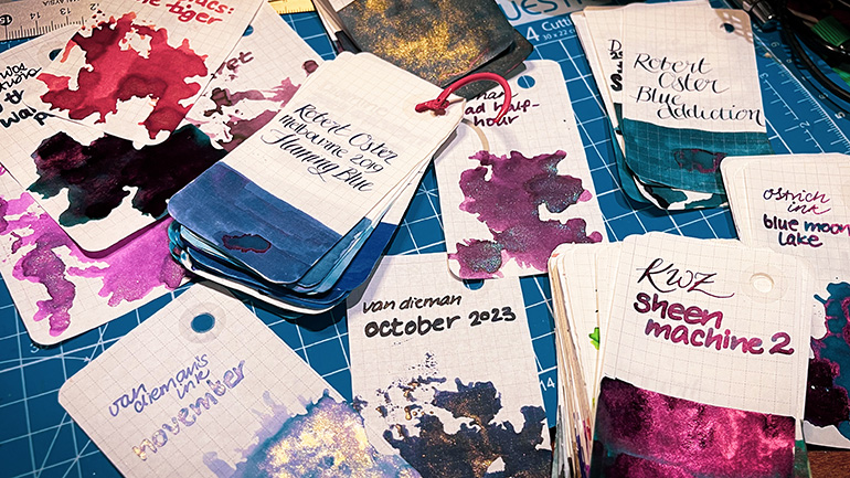 A scatter of ink swatch cards in a range of colours and finishes