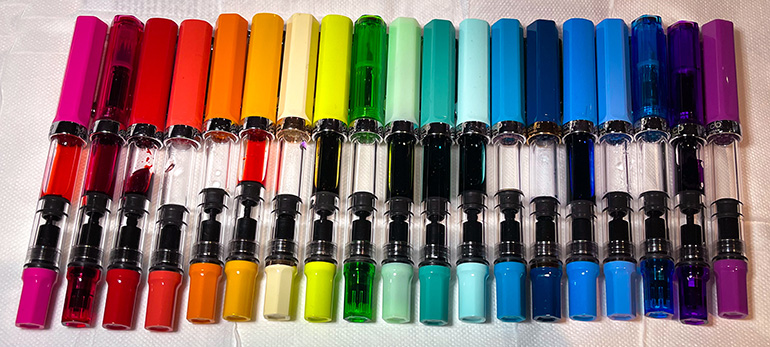 Nineteen TWSBI Ecos in a row, in rainbow order